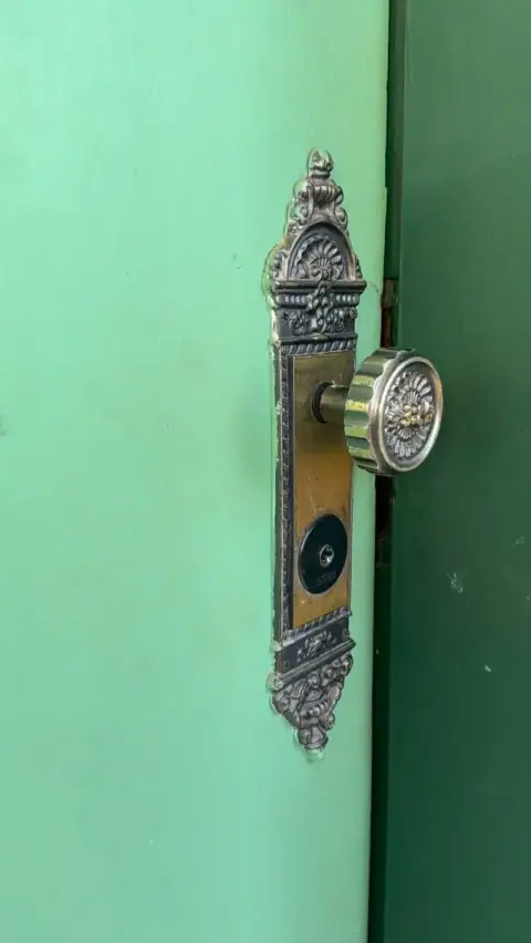 Fechadura ornamentada em uma porta verde